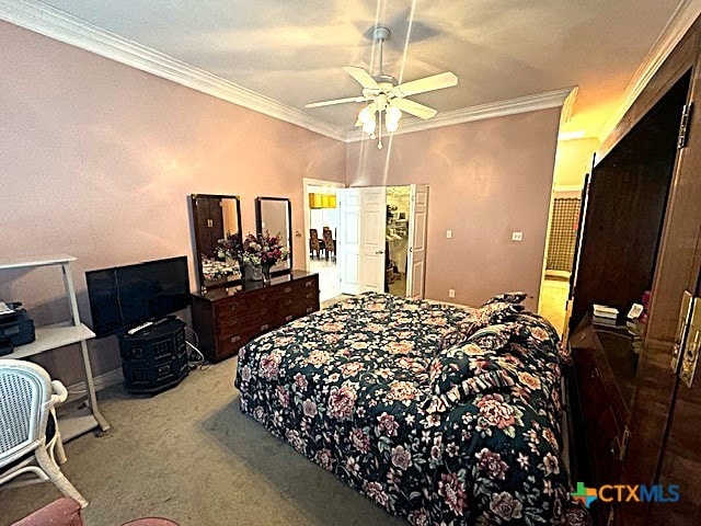 bedroom with ceiling fan, carpet, and ornamental molding