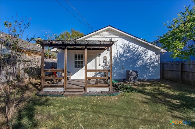 back of property with a yard and a deck