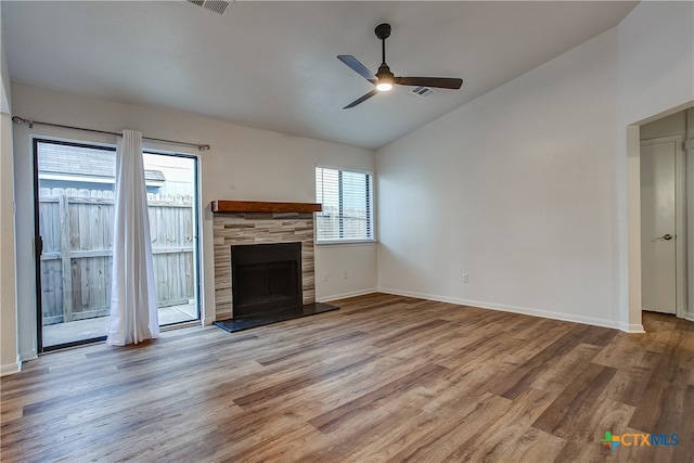 unfurnished living room featuring light hardwood / wood-style flooring, ceiling fan, a tile fireplace, and vaulted ceiling