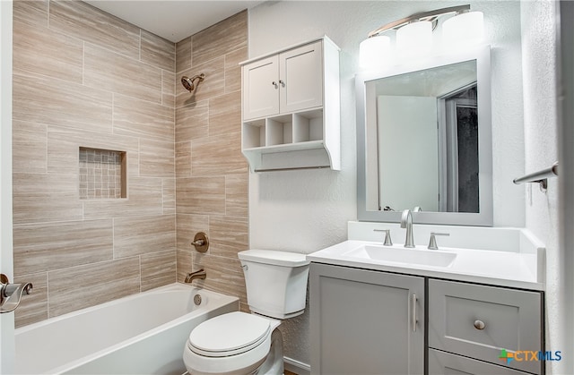 full bathroom with vanity, tiled shower / bath combo, and toilet