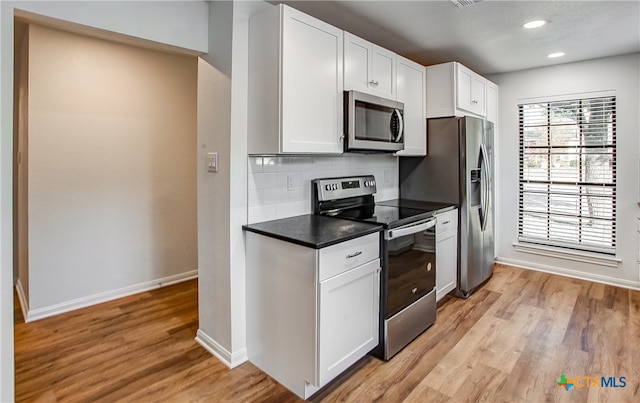 kitchen with white cabinetry, appliances with stainless steel finishes, and light hardwood / wood-style flooring