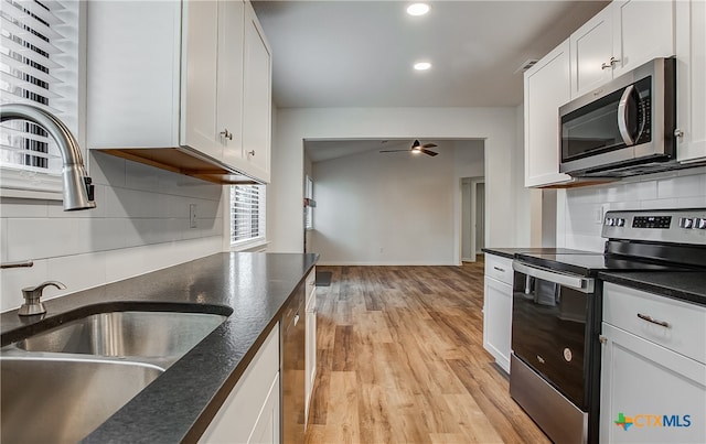 kitchen with white cabinets, stainless steel appliances, light hardwood / wood-style floors, and ceiling fan