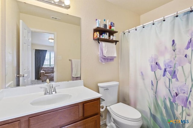 full bathroom featuring toilet, curtained shower, visible vents, and vanity