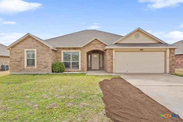 ranch-style home with an attached garage, brick siding, concrete driveway, and a front yard