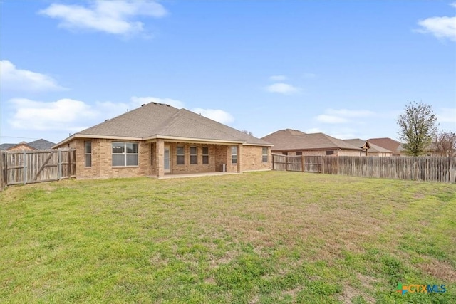 back of property featuring a patio area, brick siding, a lawn, and a fenced backyard