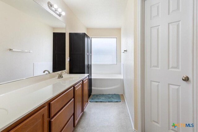 full bath with a bath, tile patterned flooring, and vanity