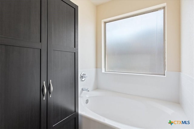 bathroom featuring a healthy amount of sunlight and a bath