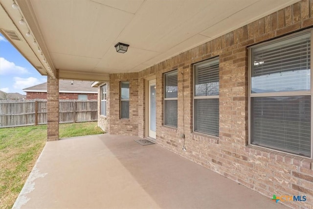 view of patio with fence and visible vents