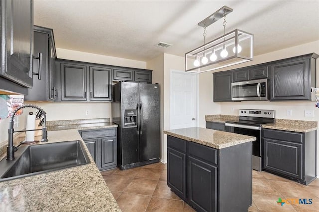 kitchen with a center island, hanging light fixtures, stainless steel appliances, a sink, and light tile patterned flooring