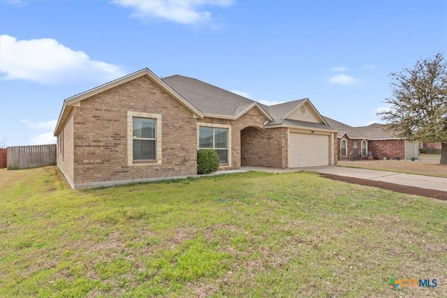 ranch-style home with a garage, concrete driveway, brick siding, and a front lawn