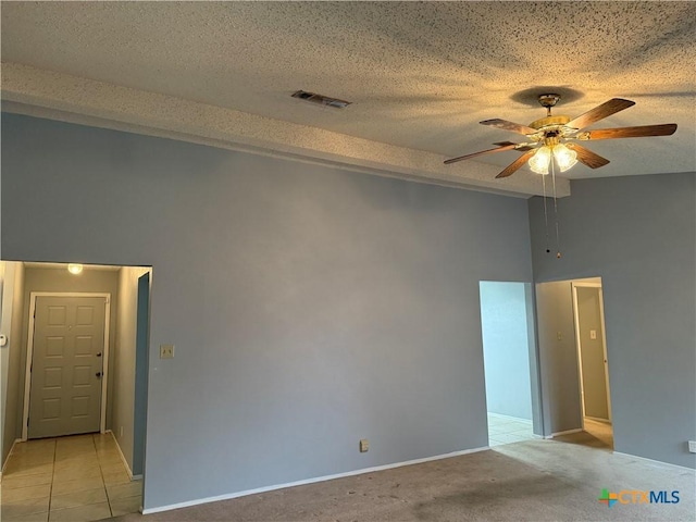 empty room with a textured ceiling, light carpet, visible vents, and a ceiling fan