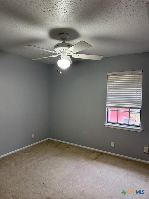 carpeted empty room with a textured ceiling and ceiling fan