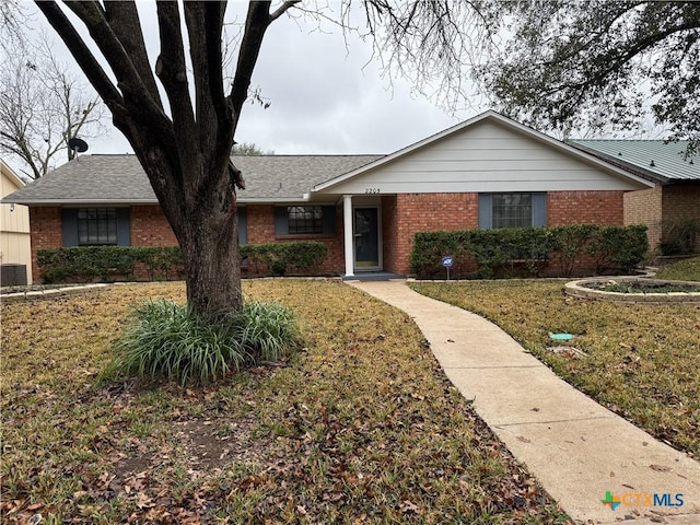 ranch-style home with brick siding and a front lawn