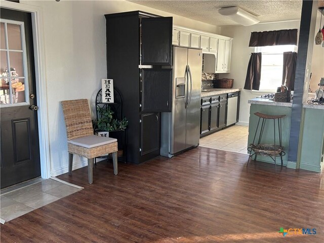 kitchen with sink, white cabinetry, hanging light fixtures, stainless steel appliances, and backsplash