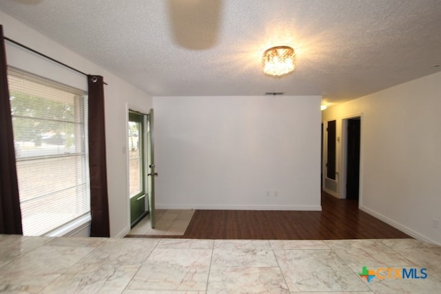 unfurnished room featuring a textured ceiling