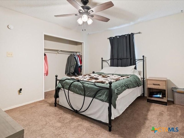 carpeted bedroom featuring a textured ceiling, ceiling fan, and a closet