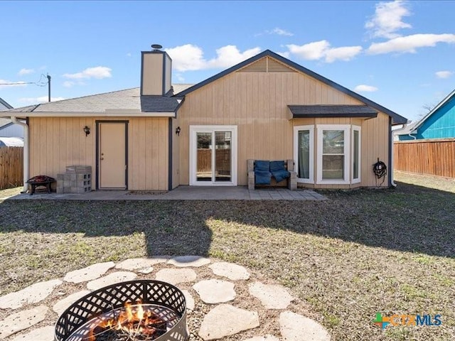 rear view of house featuring a lawn, a patio, and an outdoor fire pit