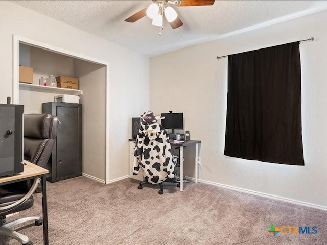 carpeted home office with ceiling fan and a textured ceiling