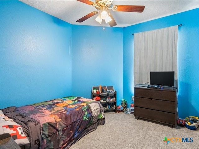 bedroom featuring light carpet, a textured ceiling, and ceiling fan