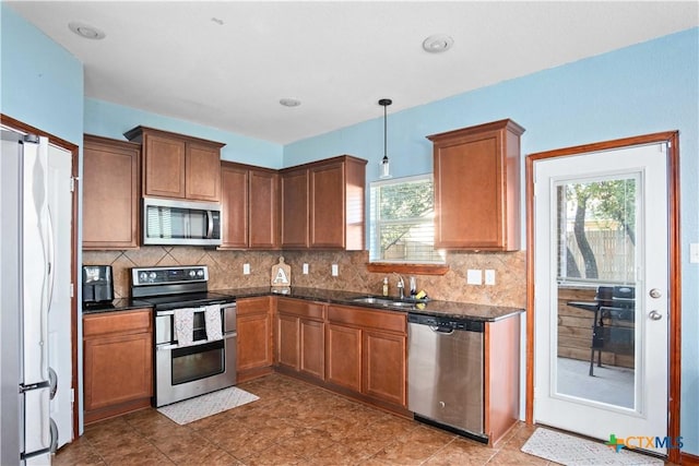 5310 Dauphin Dr, Belton, TX 76513 - kitchen featuring decorative light fixtures, stainless steel appliances, decorative backsplash, a sink, and brown cabinetry