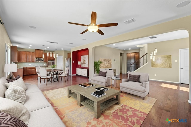 kitchen with appliances with stainless steel finishes, a center island, dark wood-type flooring, sink, and hanging light fixtures