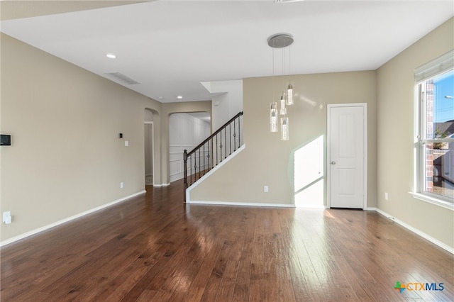 unfurnished living room with ceiling fan and dark hardwood / wood-style flooring