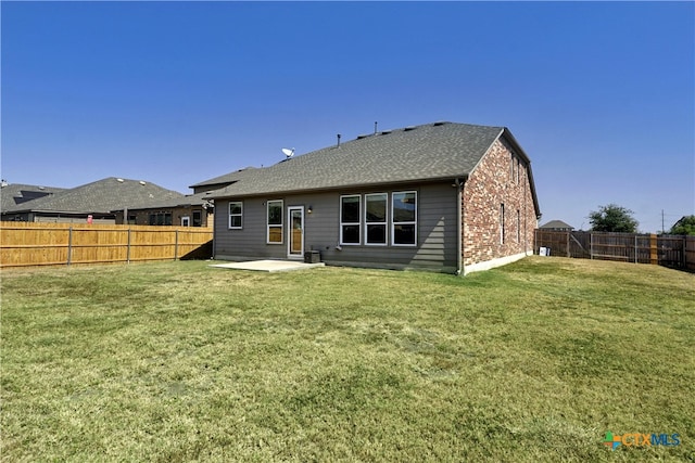 back of property with a patio area and a lawn