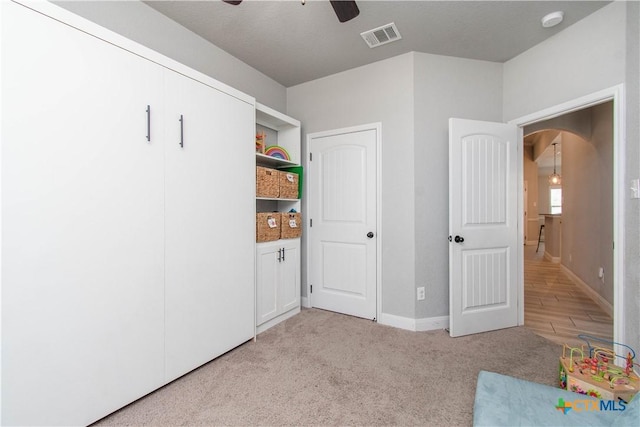 game room featuring visible vents, baseboards, light colored carpet, arched walkways, and a ceiling fan