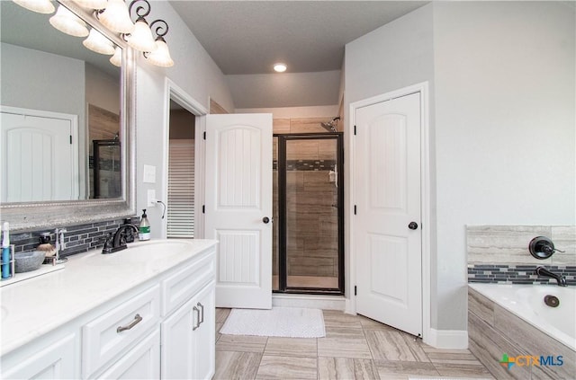 bathroom featuring decorative backsplash, a garden tub, a stall shower, and vanity