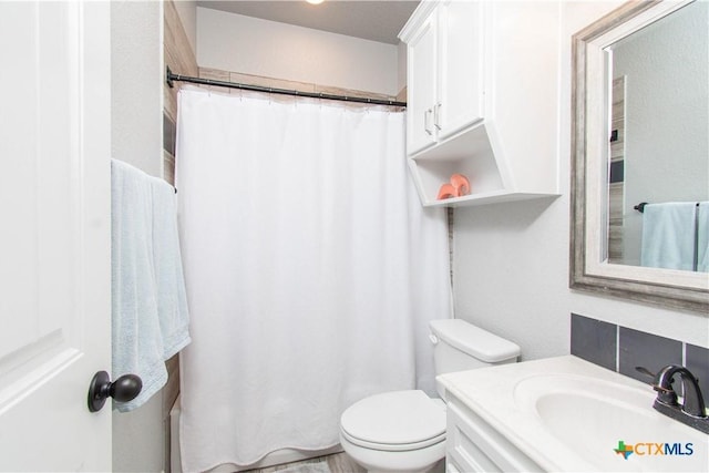 bathroom featuring vanity, toilet, and a shower with shower curtain