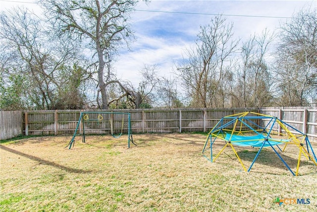 view of yard featuring a playground and a fenced backyard