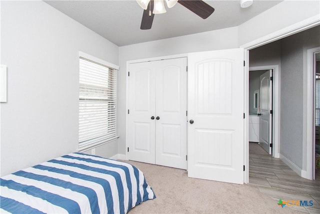 carpeted bedroom with baseboards, a closet, and ceiling fan