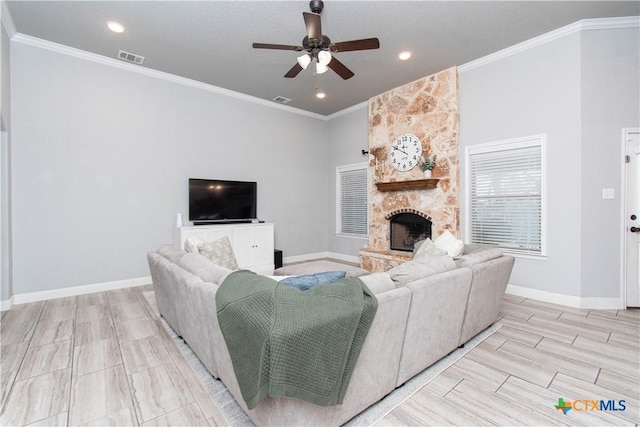 living area with ornamental molding, a fireplace, baseboards, and ceiling fan