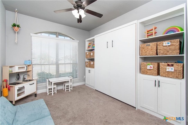 game room with a sink, baseboards, ceiling fan, and carpet flooring