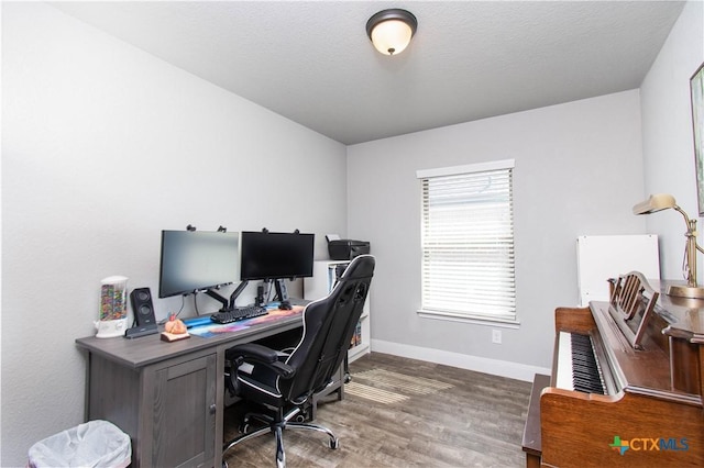 office area featuring a textured ceiling, baseboards, and wood finished floors