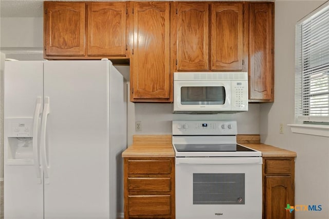 2209 Winchester Dr, Temple, TX 76502 - kitchen featuring white appliances, light countertops, and brown cabinetry