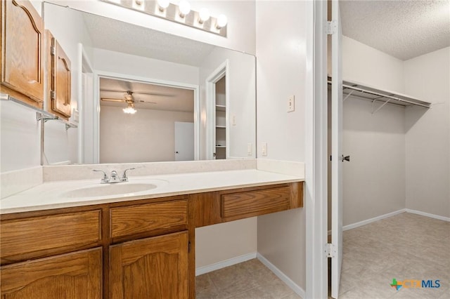 2209 Winchester Dr, Temple, TX 76502 - bathroom with vanity, a spacious closet, and a textured ceiling