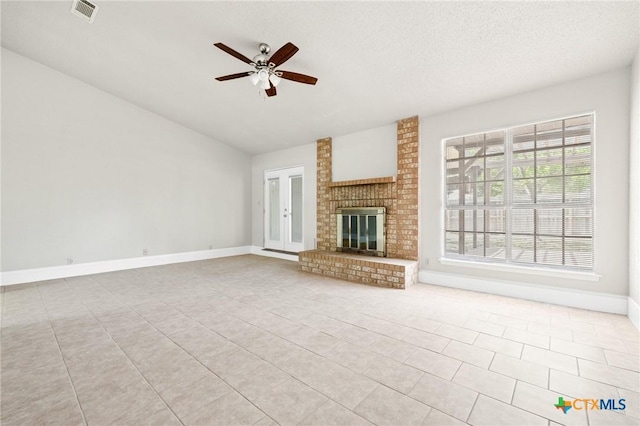 2209 Winchester Dr, Temple, TX 76502 - unfurnished living room featuring ceiling fan, vaulted ceiling, tile patterned floors, a fireplace, and a textured ceiling