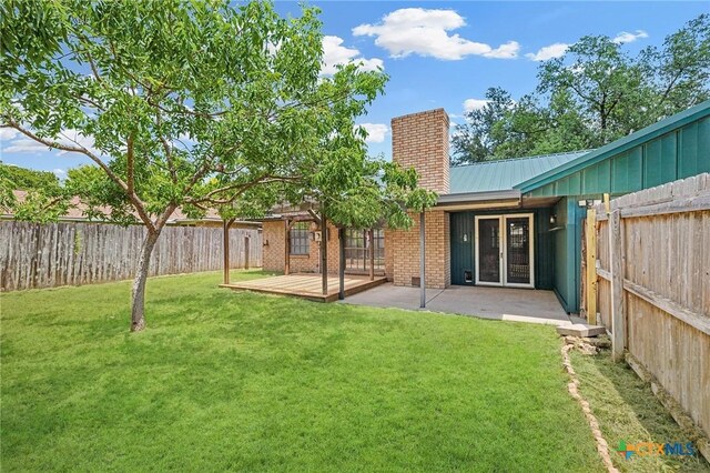 2209 Winchester Dr, Temple, TX 76502 - back of property featuring a chimney, a fenced backyard, a metal roof, and a patio area