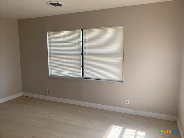 unfurnished room with a wealth of natural light and light wood-type flooring