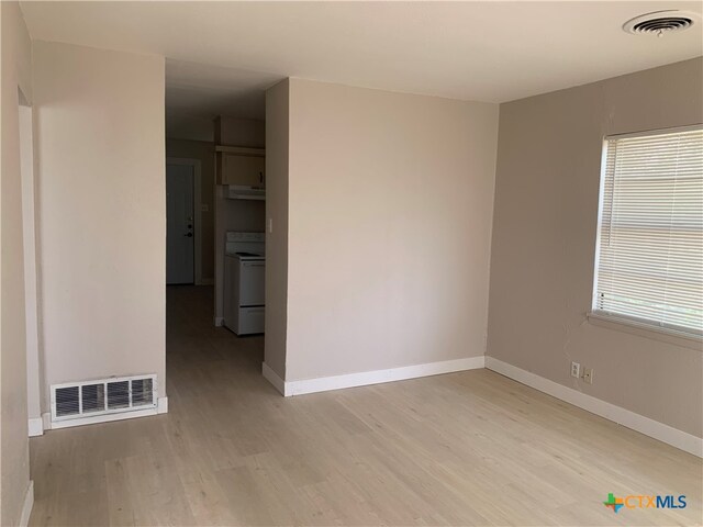 empty room featuring plenty of natural light and light hardwood / wood-style floors