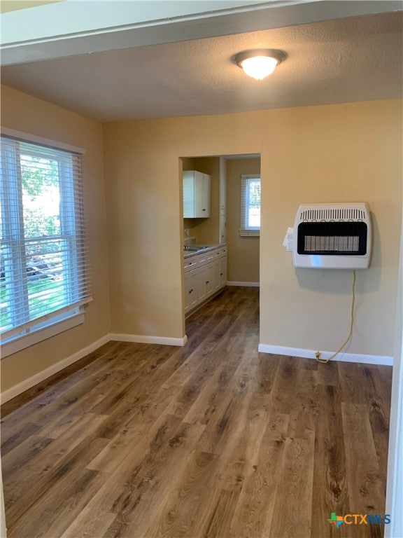 interior space with heating unit and dark hardwood / wood-style flooring