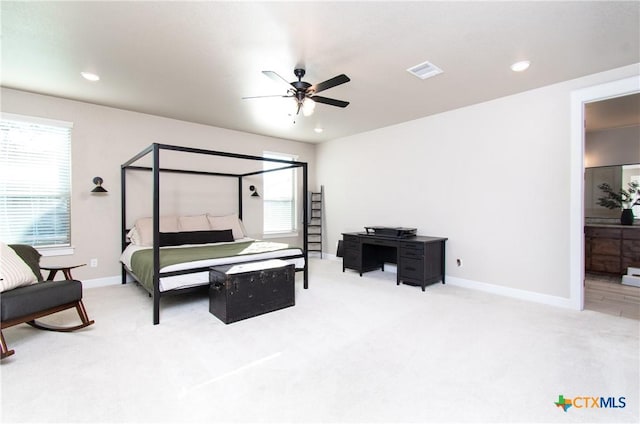 bedroom with multiple windows, ceiling fan, carpet floors, and ensuite bathroom