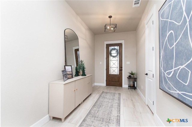 entryway with a chandelier