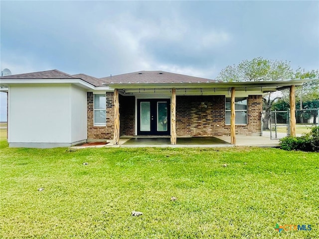 rear view of house featuring a yard and a patio