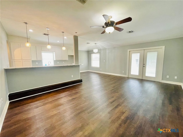 unfurnished living room with ceiling fan, dark hardwood / wood-style flooring, sink, and french doors