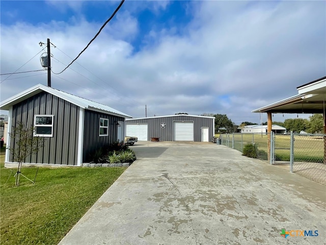 view of side of property with a yard, an outdoor structure, and a garage