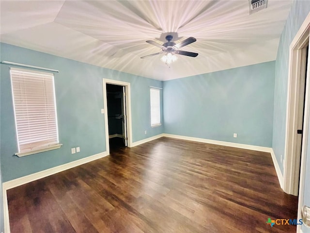 interior space featuring a spacious closet, a closet, ceiling fan, and dark hardwood / wood-style floors