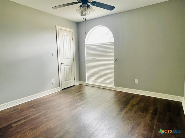 unfurnished room with ceiling fan and dark hardwood / wood-style flooring