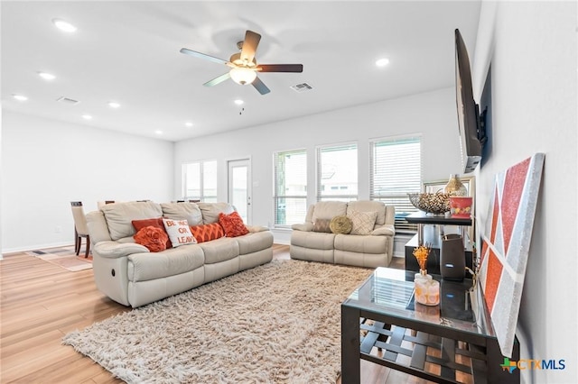 living room featuring visible vents, baseboards, recessed lighting, light wood-style floors, and a ceiling fan